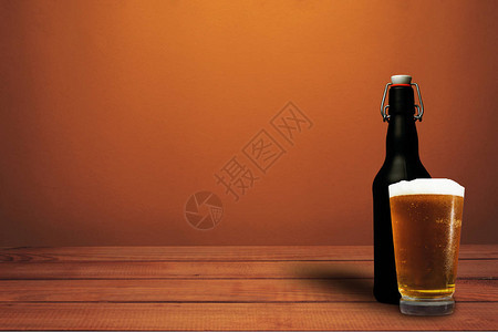 一杯红木桌上的啤酒和黑瓶啤酒美丽的橙色墙壁背景图片
