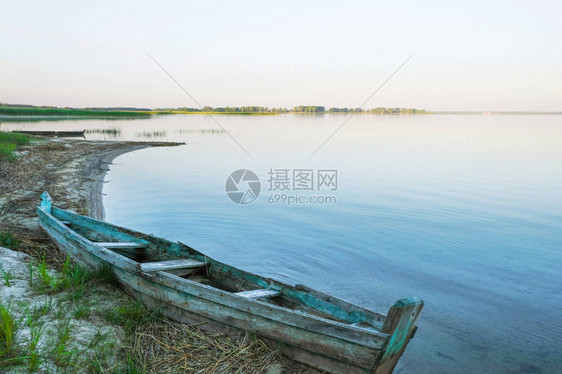 一艘老木船停在大湖沙滩上斯维提亚兹湖日出乌克兰自图片