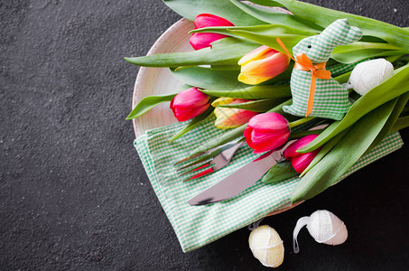复活节桌布满了郁金香和餐具的花束准备庆祝复活节晚图片