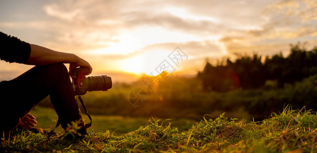 自然摄影师摄影师坐着看日落图片