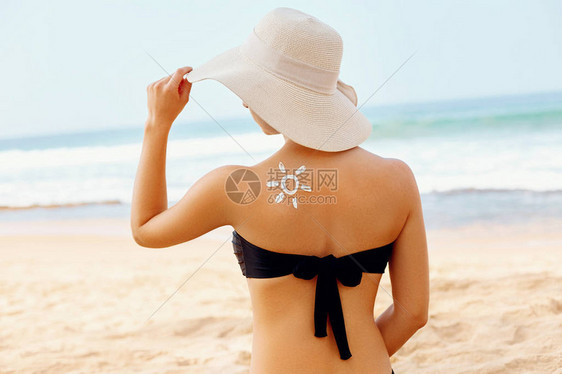 比基尼美女在晒黑的肩膀上涂抹防晒霜防晒皮肤和身体护理使用防晒霜涂图片