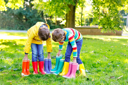 带着很多五颜六色的雨靴孩子们穿着不同的橡胶靴和夹克秋季雨鞋健康的双胞胎和最好的朋友在图片