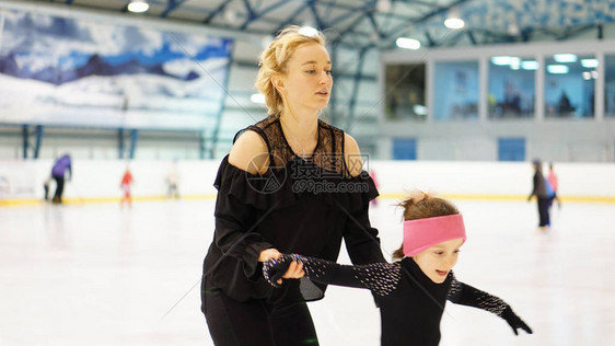 花式滑冰训练中女教练在室内溜冰场训练穿黑色紧图片