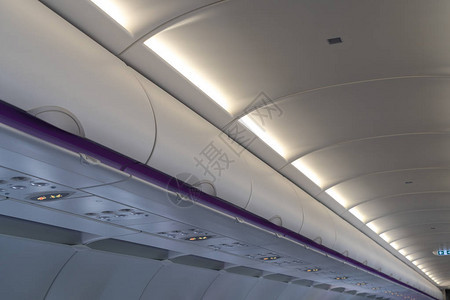 商用飞机头顶储物箱中的随身行李飞机客舱内部的细节拍摄具有复制空图片