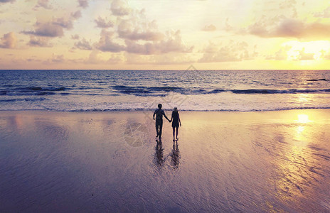 快乐的亚洲夫妇在户外度假蜜月旅行期间在海滩约会泰国普吉岛日落时的图片