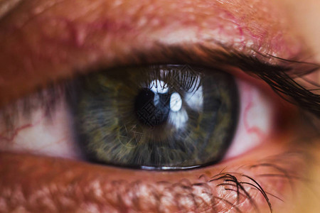 用鲜红色的动脉打开人眼关闭眼球刺激和发红瞳孔虹膜睫毛在宏背景图片