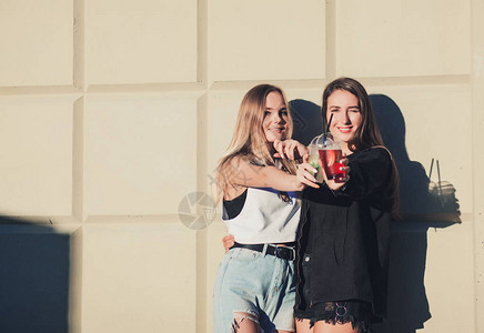 两个年轻美丽的笑着时装女孩穿着流行的夏季时装服图片