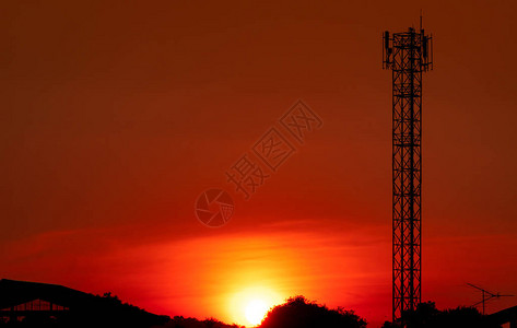 美丽的红色和橙色日落天空晚上剪影电信塔和树与美丽的红色日落天空和云图片