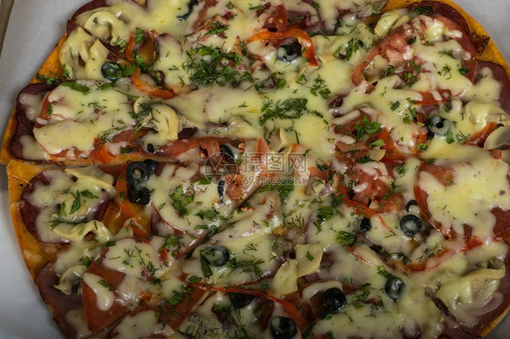 用餐桌上的香肠牛肉西红柿和橄榄寻找比萨饼图片