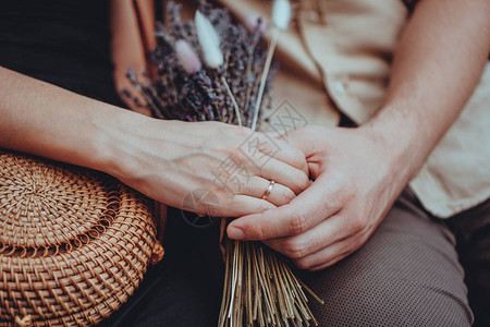女孩手中的薰衣草花束订婚戒指在手边爱手牵的情侣爱情人际关系旅行图片