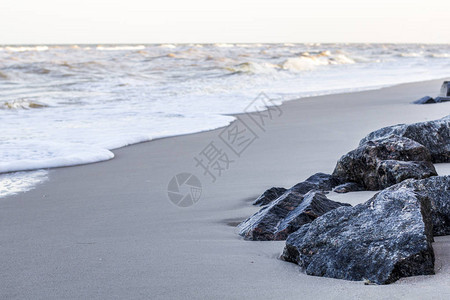 沙滩上的石头海浪图片