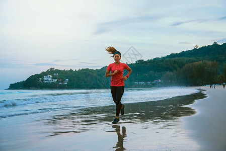 女人早上在海滩上慢跑锻炼在海上漫步放松身心在沙滩上慢跑图片