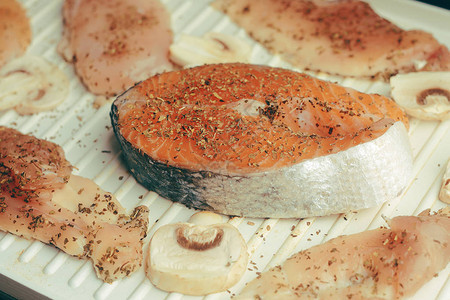 三文鱼的照片鲜红鱼色丰富烤架上的蘑菇和鸡柳在香料干罗勒盐胡椒中三文鱼在电烤罗勒图片
