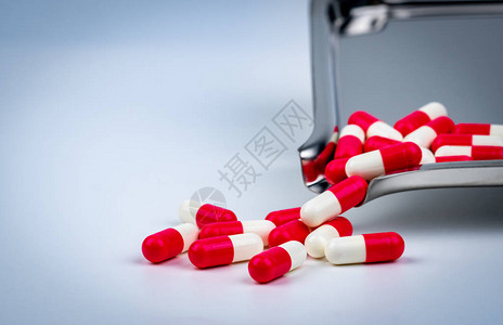 不锈钢药物托盘上的红白色胶囊丸和一些在白色桌子上药房店背景药剂学概念医药行业医院里的药图片