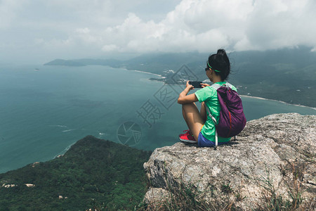 在海边山顶与智能手机拍摄成功妇女希克Hiside图片