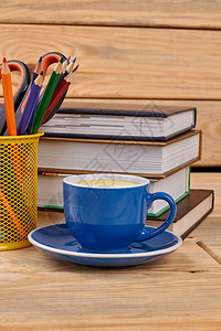 书籍铅笔和咖啡杯办公桌上有一堆书铅笔在支背景图片