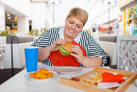 在商场食品法庭吃快餐的胖女人超重女和垃图片