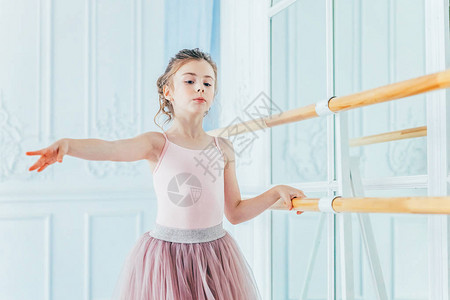 舞蹈课上的年轻古典芭蕾舞演员女孩美丽优雅的芭蕾舞女演员在白光大厅的大附近穿着粉色短裙图片