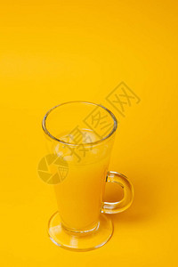 沙滩上放松和口渴的概念黄色背景的柠檬水杯图片