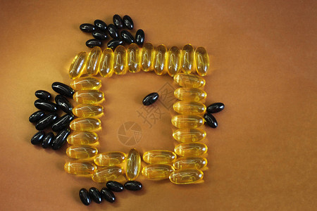 维生素黄色鱼油椭圆形健康鱼油以鱼的形式位于明亮的背景上背景图片