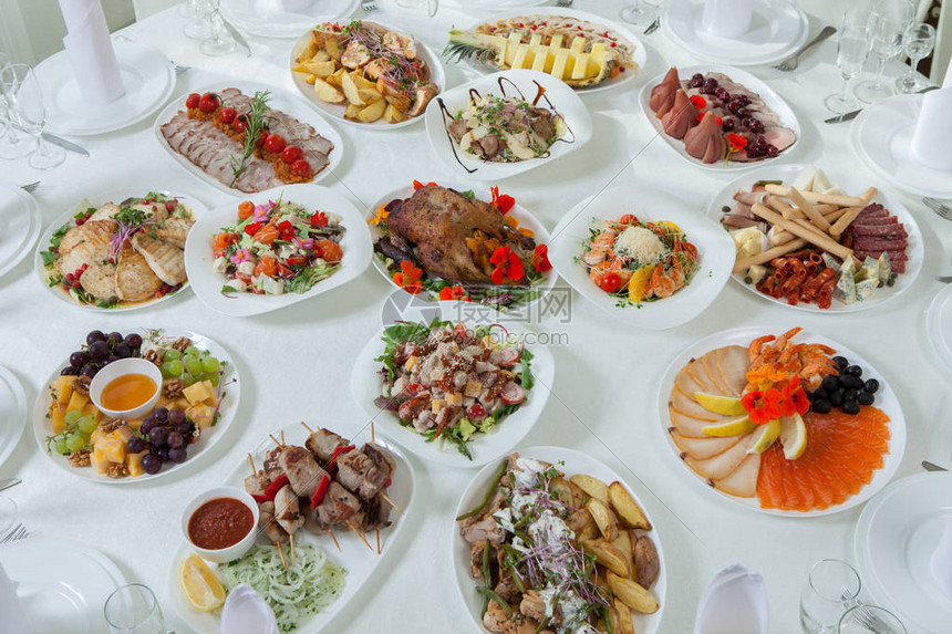 美丽的节日餐桌为家庭或餐厅内部的婚礼庆祝晚宴提供服务餐厅的餐桌上摆满了食物完图片