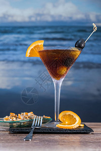 玻璃桌上放着冰橄榄柠檬片和鸟蛤的红色鸡尾酒图片