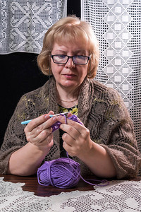 女人用钩针编织装饰餐巾披肩和围巾图片