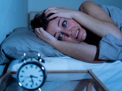 失眠和绝望的美丽白种女人晚上醒来无法入睡图片素材