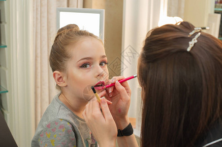 一个小女孩在舞台表演前化妆在更衣室表演前的准备工作化妆师在美容院给孩子化妆发型图片