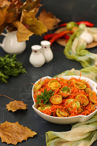 深色背景的白色沙拉碗里放着绿色西红柿和胡萝卜的韩式沙图片