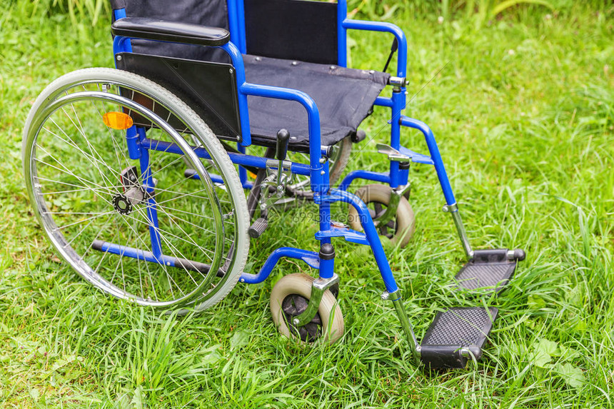 空轮椅站在医院公园的草地上等待病人服务在大自然中停放在户外的残疾人椅子无效障碍无障碍符号图片