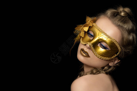 威尼斯嘉年华化妆舞会或新年晚会的金面罩上披着派对面具的图片