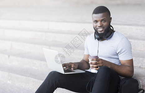 微笑的非洲学生在户外编码和喝咖啡全图片