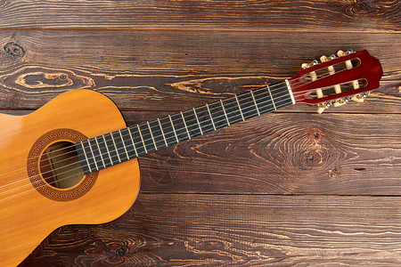 棕色纹理木头上的吉他木桌上的原声吉他与文本空间民图片