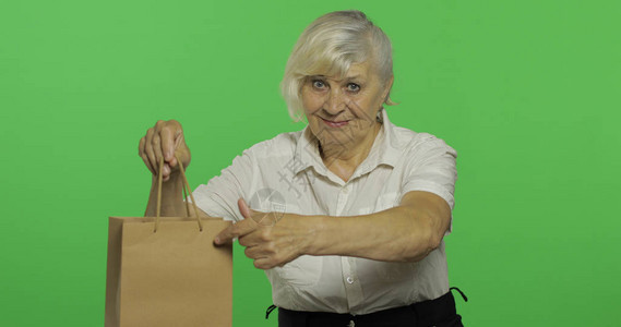 一位提着购物袋的老妇人图片