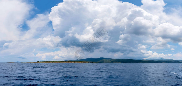 从海上看海岸大海和天空中暴风雨云的全景图片
