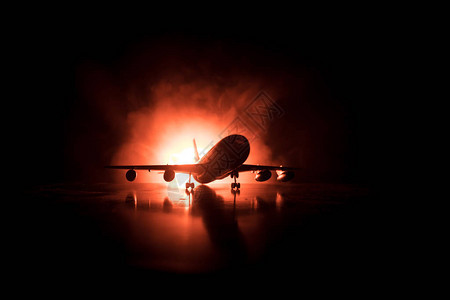 艺术品装饰白色客机准备从机场跑道起飞夜间飞机的剪影图片