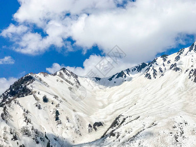 美丽的雪山风景与蓝色天空和云彩在日本地高山的田山村图片