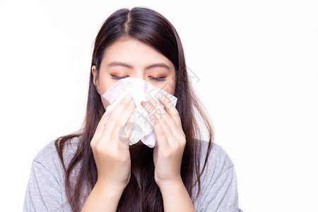 美丽的亚洲女人感冒或流感她感到恶心和头晕漂亮的女孩用纸巾擤鼻涕她有鼻塞或鼻塞和流鼻涕背景图片