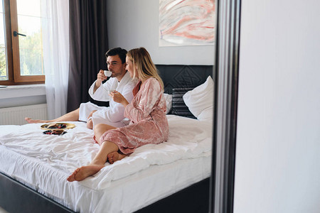 年轻夫妇在现代舒适酒店的床上图片
