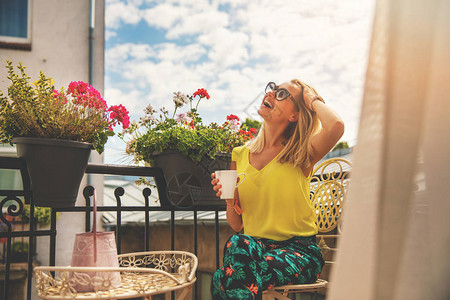 享受假期和在酒店阳台喝咖啡的有吸引力的图片