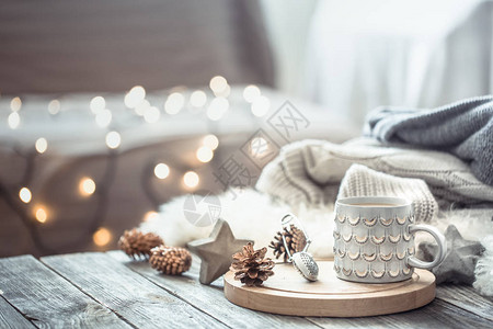 巧克力牛奶飞溅圣诞灯上的咖啡杯在家里的木桌上散景背景