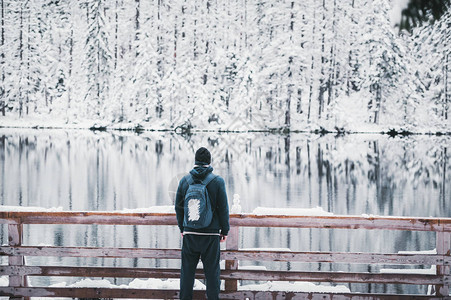 年轻人旅行者留在雪山湖上小雪人就在附近图片