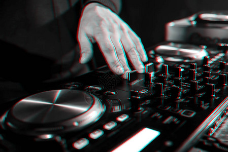 夜总会音乐控制面板上DJ控制器的手移动具有故障效果和小颗图片
