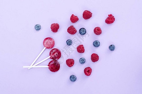 三个红色棒糖蓝莓和草莓图片