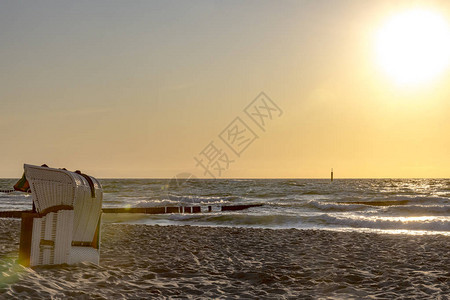 沙滩椅站在波罗的海滩的日落中大海图片