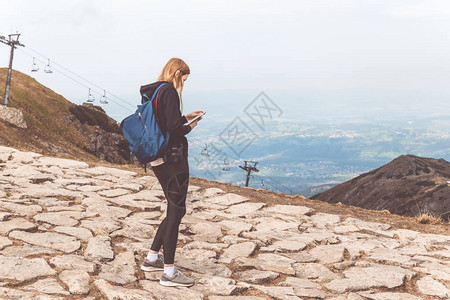一个穿黑色毛衣的瘦女孩站在山上用图片