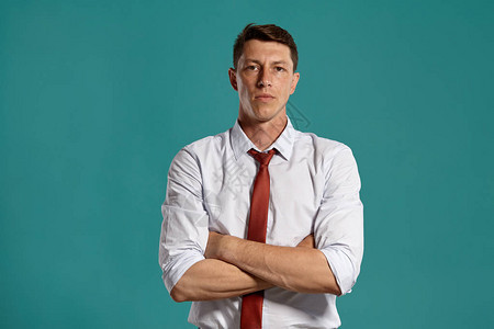 一位穿着经典白衬衫和红领带的有情调的年轻男在工作室肖像画背景图片