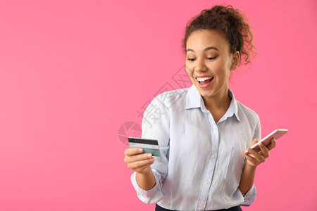 拥有信用卡和手机彩色背景的非洲裔美国快乐女info背景图片
