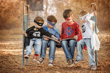 四个穿着超级英雄服装的男孩在夏日背景图片